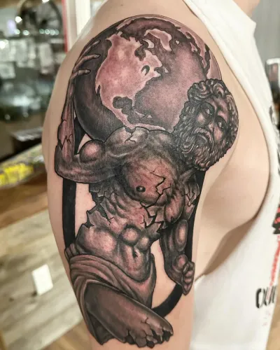 Black and grey cherub statue holding a cracked globe on a shoulder — by Adam Crane at Ministry Ink