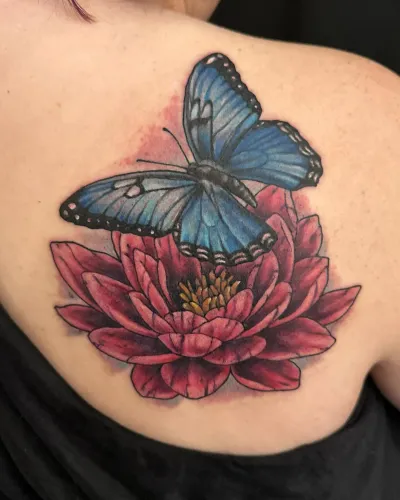 Colour blue morpho butterfly resting on a red lotus flower, on the chest — by Adam Crane at Ministry Ink