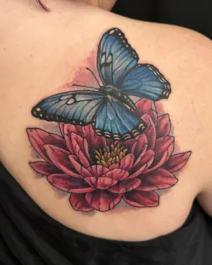 Colour blue morpho butterfly resting on a red lotus flower, on the chest — by Adam Crane