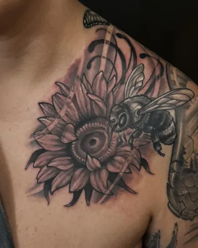 Black and grey sunflower and honeybee shoulder piece — by Adam Crane at Ministry Ink