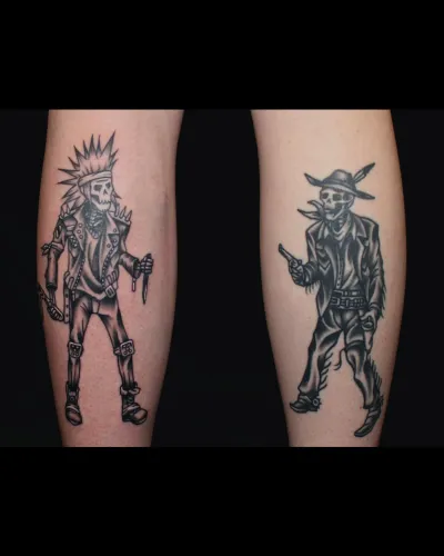 A matching pair of black and grey character tattoos, one on each calf — by Chay Menke at Ministry Ink