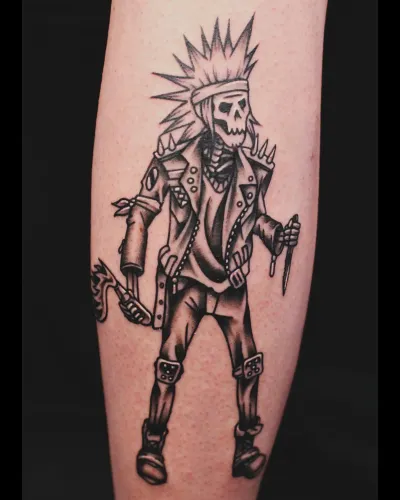 Black and grey punk skeleton figure striding, on a calf — by Chay Menke at Ministry Ink