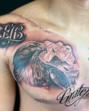 Black and grey eagle and mountain chest piece with Grateful script — by Chay Menke