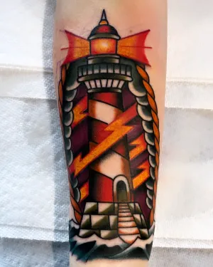 Colour American traditional lighthouse with red beams on a forearm — by Chay Menke
