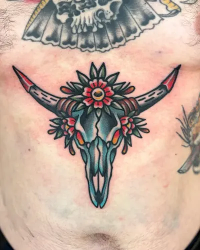 American traditional longhorn skull with flowers across a sternum — by Chay Menke at Ministry Ink