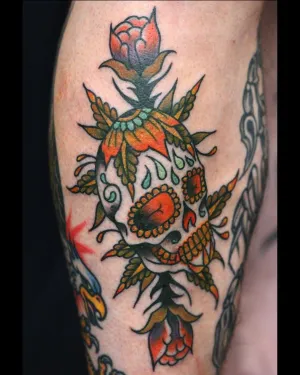 Colour sugar skull with roses on an upper arm — by Chay Menke