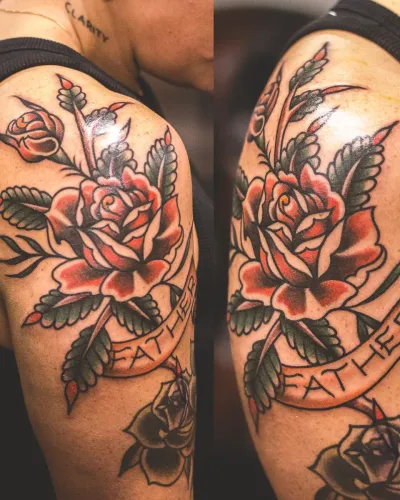 Black and grey roses with a Leather banner across a shoulder — by Chay Menke at Ministry Ink