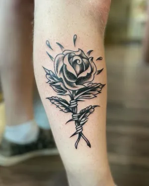 Black and grey rose with crossed stems on a calf — by Chay Menke