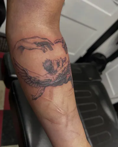 Fine line dragon curling around a forearm — by Gabriel Gonzalez at Ministry Ink