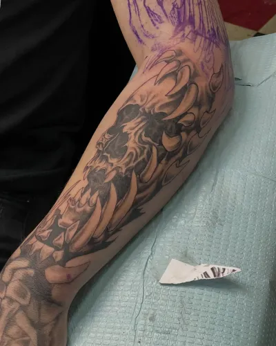 Black and grey leg sleeve in progress with stencil still visible — by Gabriel Gonzalez at Ministry Ink
