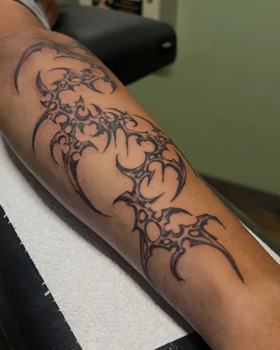 Fine line thorned vine wrapping a forearm — by Gabriel Gonzalez at Ministry Ink